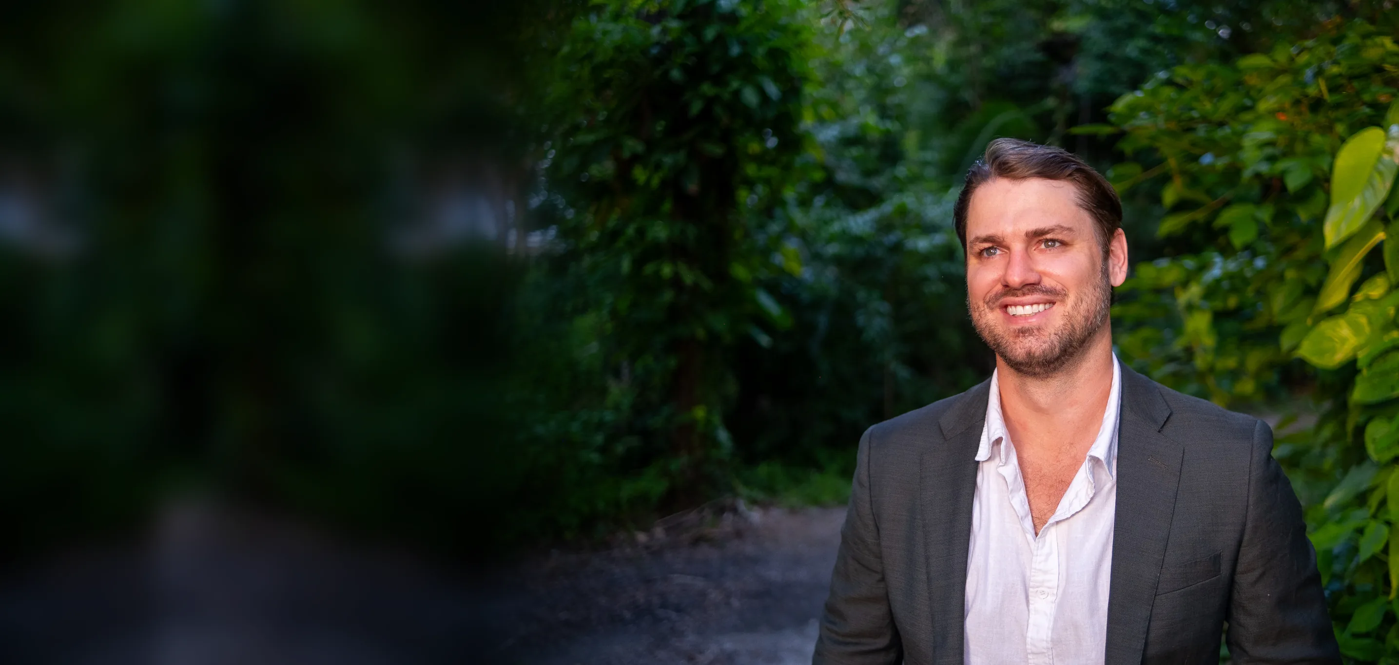 Elliot Taylor, smiling, on a shaded Lee County path at golden hour.
